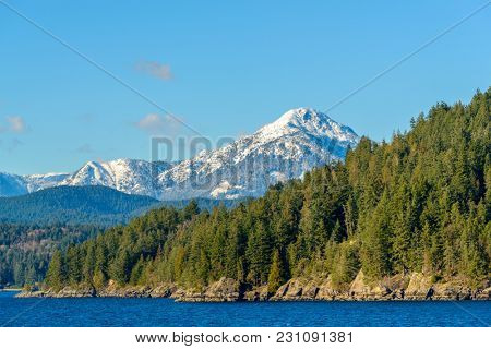 Fantastic view over ocean, snow mountain and rocks at Sechelt inlet in Vancouver, Canada.