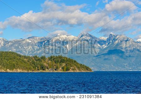 Fantastic view over ocean, snow mountain and rocks at Sechelt inlet in Vancouver, Canada.