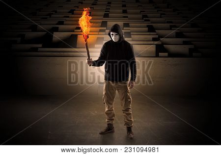 aberrant man coming out from the labyrinth with burning flambeau on his hand
