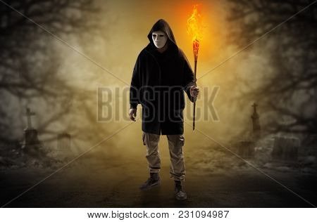 Man with burning flambeau coming from thicket and looking something