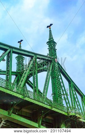 Closeup On Liberty Bridge Or Szabadsag Green Metal Structure With Coat Of Arms In Budapest, Hungary