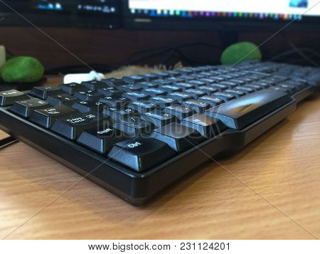 Keyboard On Working Table With Monitor On Blurred Background