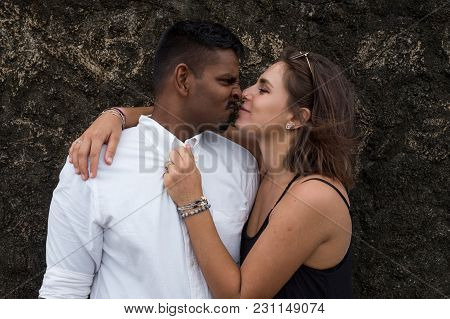 Young Mixraced Couple Kissing Near Black Wall. Concept Of True Love