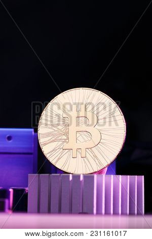 Photo of golden bitcoin and processor on pink background