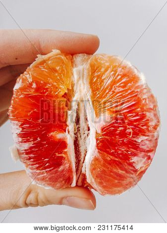 Girl Holding Half A Red Orange Vertically Close-up