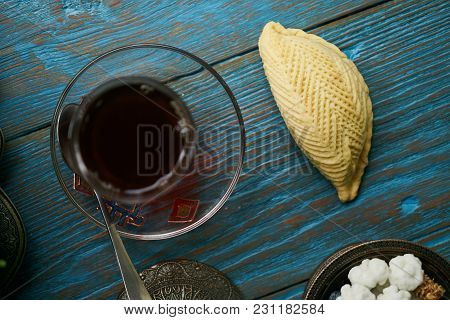 Traditional Azerbaijan Sweet Pastry Shekerbura With Nuts And Honey And Glass Of Black Tea On Wooden 