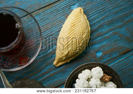 Traditional Azerbaijan Sweet Pastry Shekerbura With Nuts And Honey And Glass Of Black Tea On Wooden 