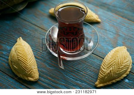 Traditional Azerbaijan Sweet Pastry Shekerbura With Nuts And Honey And Glass Of Black Tea On Wooden 