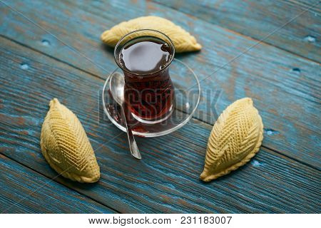 Traditional Azerbaijan Sweet Pastry Shekerbura With Nuts And Honey And Glass Of Black Tea On Wooden 
