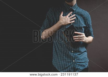 Man Holding Holy Bible. Prayer Concept For Faith Spirituality And Religion Gray Background