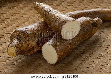 Whole and half Cassava roots on a wicker background