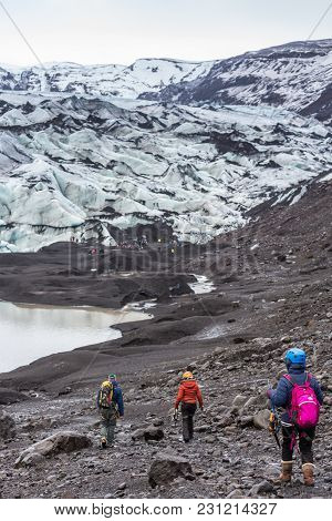 Group Of Hikers Walking To Glacier With Guide