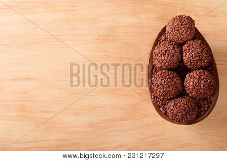 Chocolate Egg With Filling For Easter On Wooden Background
