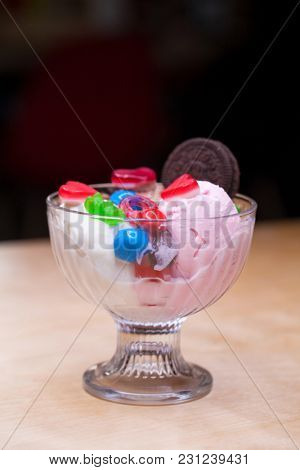 Pink ice cream croissant with biscuits and sweets