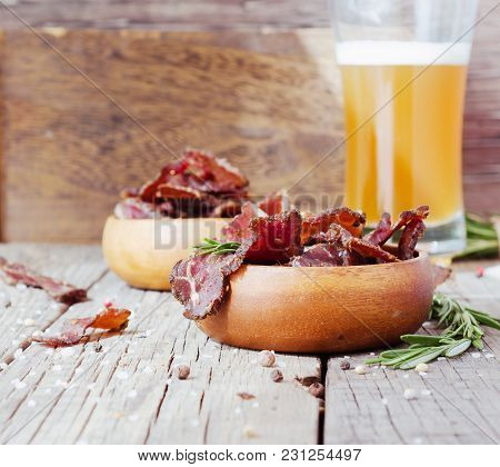 Jerked Dried Meat, Cow, Deer, Wild Beast Or Biltong In Wooden Bowls On A Rustic Table, Selective Foc