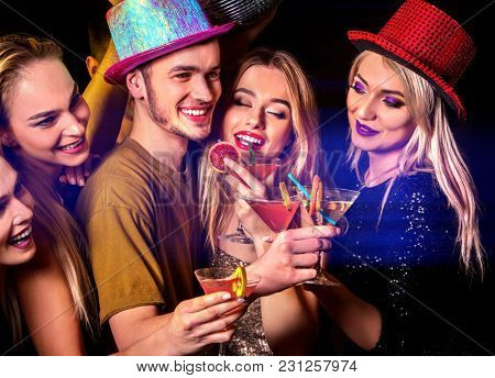 Woman disco night club. Dance party with group people dancing. Female and men have fun and drink martini cocktail with fruit in night club. Rest after hard day at work.