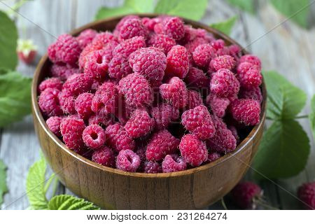 Fresh Organic Ripe Raspberry With Leaf In Bowl On Wooden Table, Selective Focus