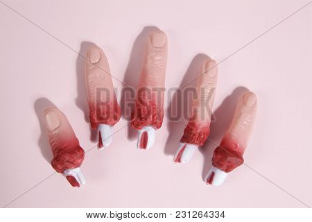 5 Fake Bloodied Plastic Fingers As If They Had Been Torn Off On A Vibrand Pink Background. Gradient 