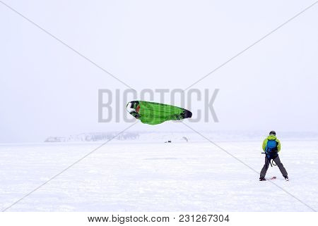 Skier-snowkiter Catches The Wind During A Snowfall