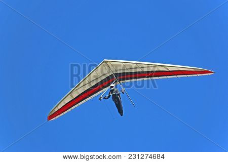 Hang Glider Flying In A Blue Sky