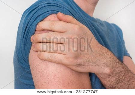Man With Shoulder Pain Is Holding His Aching Arm - Body Pain Concept