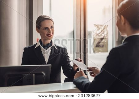 Young Businesswoman Giving Ticket To Staff At Airport Check In Counter
