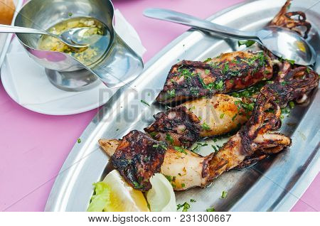 Grilled Squid With Garlic, Olive Oil And Parsley Served On A Plate