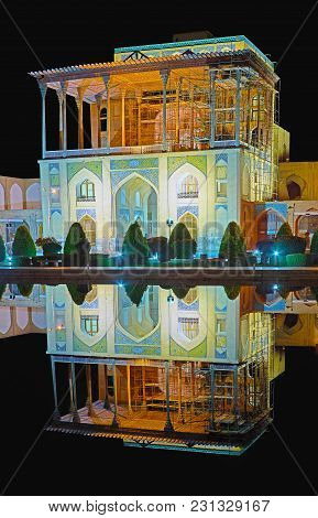 The Night Lights In Naqsh-e Jahan Square, Medieval Qapu Palace Is Reflected In Black Mirror Of The F
