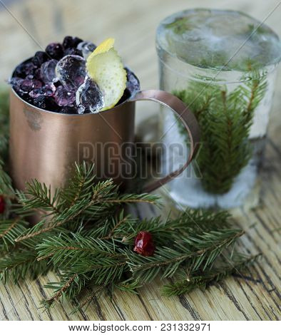 Winter Cocktail In An Old Mug Decorated With Pine Needles And Berries