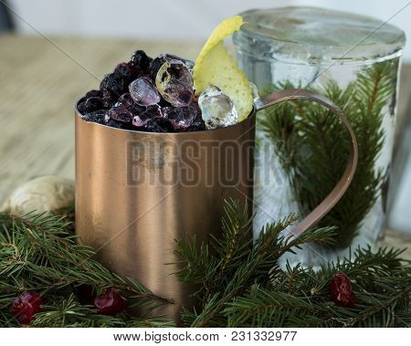 Winter Cocktail In An Old Mug Decorated With Pine Needles And Berries