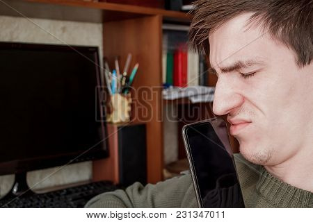 The Guy Screwed Up His Eyes, Closed The Rum With A Black Smartphone, In The Workplace
