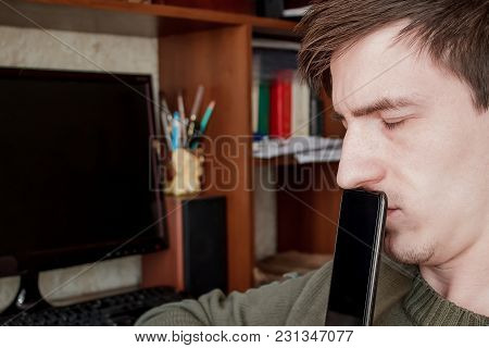 The Guy Closed His Eyes, Closed The Rum With A Black Smartphone, In The Workplace