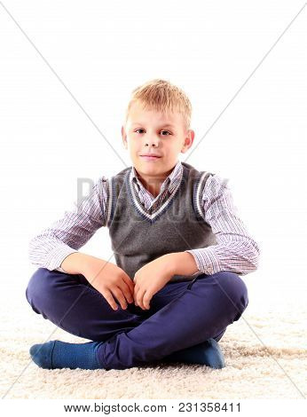 Beautiful Teenager Looking At Camera And Smiling While Sitting On The Floor On A White Background