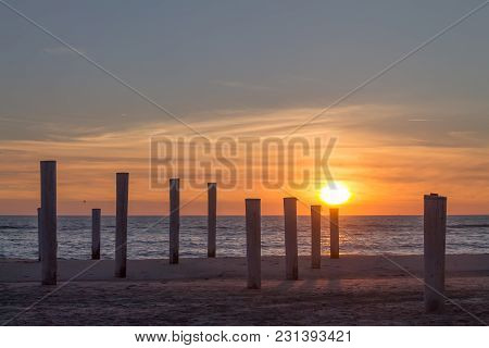 Wooden Piles On An Empty Beach And A Beautiful Sunset Sky Over The Sea, Petten, Holland,north Sea
