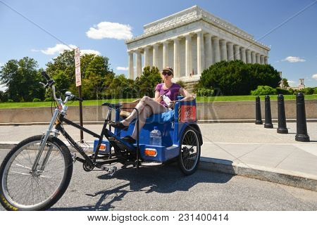 WASHINGTON DC / UNITED STATES - JUNE 01 2014: A pedicab sightseeing tour operator with Lincoln Memorial background - Washington DC United States
