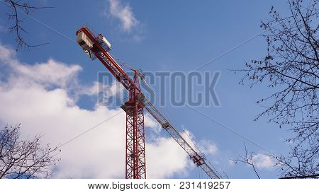 Construction Tower Crane Against Blue Sky And White Clouds
