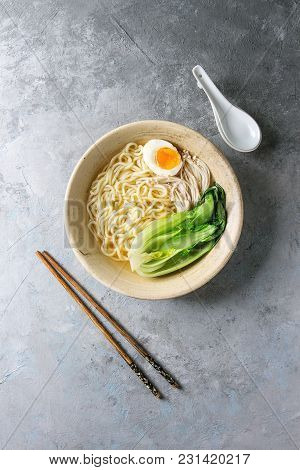 Asian Dish Udon Noodles With Boiled Egg, Mushrooms, Boc Choy Served In Ceramic Bowl With Spoon And C