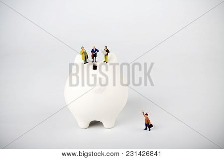 Businessman Figurines On A Piggybank. Money, Business, Corruption And Expectation Concept.