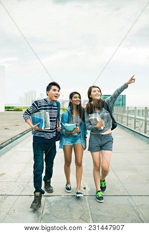 Group Of Excited Vietnamese College Students With Books Looking At Something Interesting