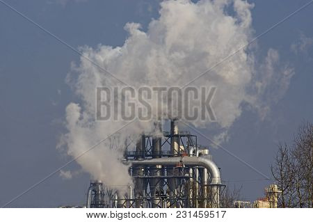 A Vast, Flat Area. In The Distance You Can See A Factory, A Shiny Metal Structure .. From The Chimne