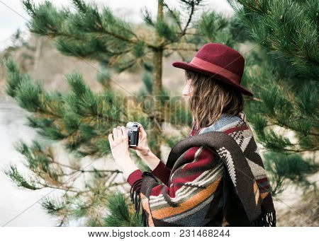 Young Woman Photographing In A Forest Holding A Vintage Camera. Kinfolk / Outdoors Style.