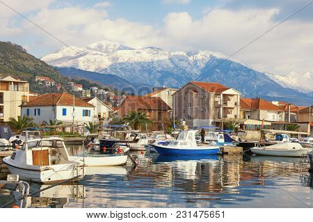 Fishing Boats In Harbor On Background Of Snowy Mountain Peaks. Montenegro, Bay Of Kotor. View Of Mar