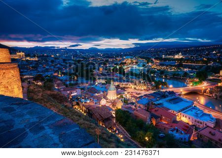 Scenic Top View Of Summer Evening Tbilisi, Georgia. Kura Mtkvari River, Surb Gevorg Church And All F