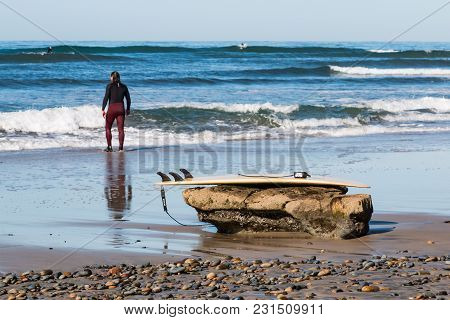 Encinitas, California/usa - February 24, 2018:  A Male Surfer Surveys The Ocean After Resting His Su