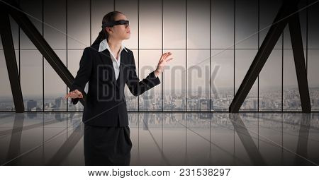 Digital composite of Business woman blindfolded against window and skyline