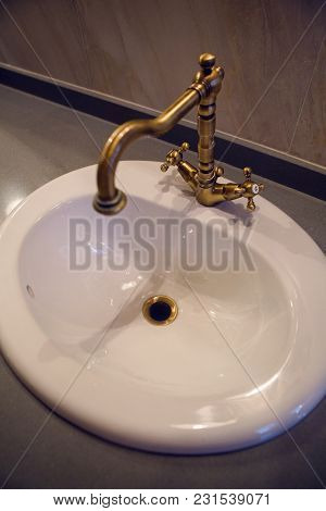 White Sink With Copper Mixer Tap In Bathroom