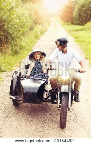 Beautiful Woman And Hansome Man On Retro Intage Motorbike. Couple In Love. Outdoor Shot With Ambient