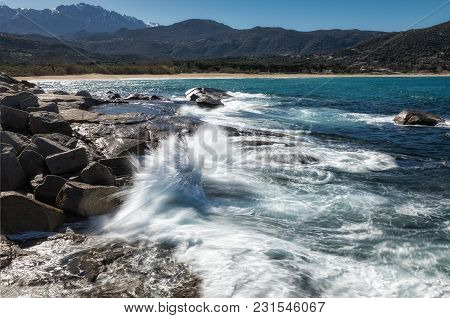 Waves Crashing Onto Rocks Near Algajola Beach In Corsica