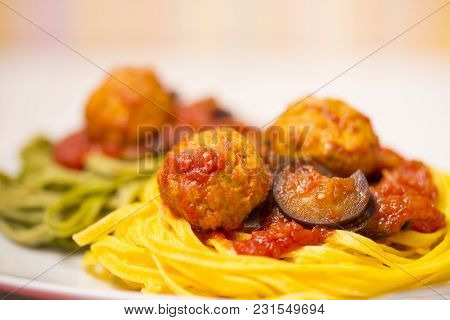Two-colour Green And Yellow Italian Coocked Pasta With Meatballs, Tomatoes And Eggplant. Close-up Ph