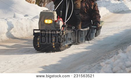 Man Riding On Crawler Mini Snowmobile With A Trailer And A Passenger On A Winter Road, Specialized V